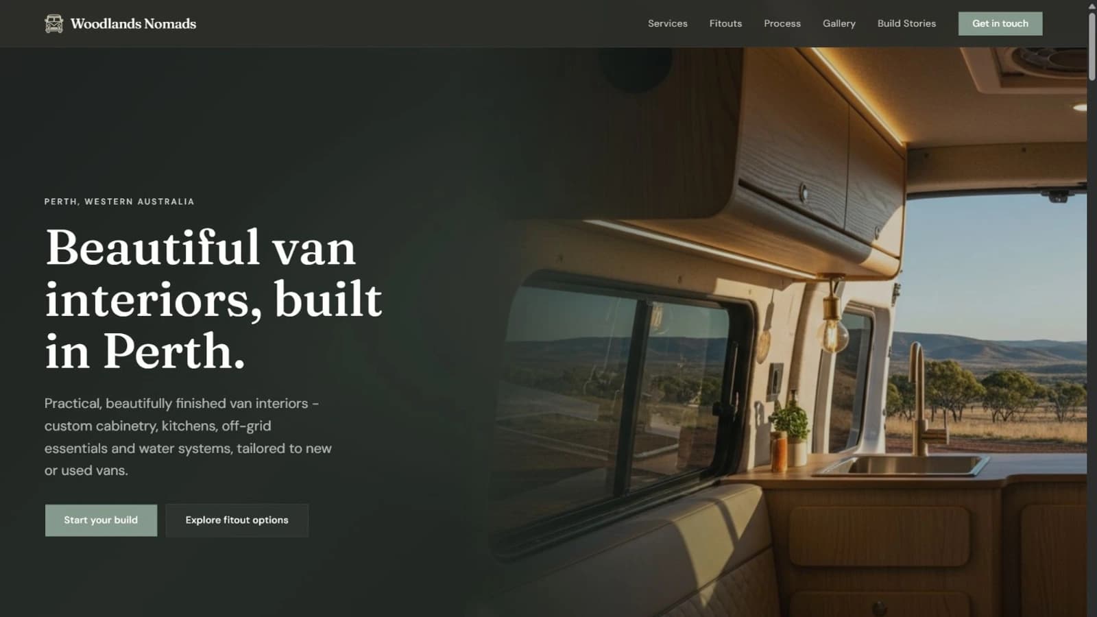Dark-mode Woodlands Nomads homepage with van interior hero